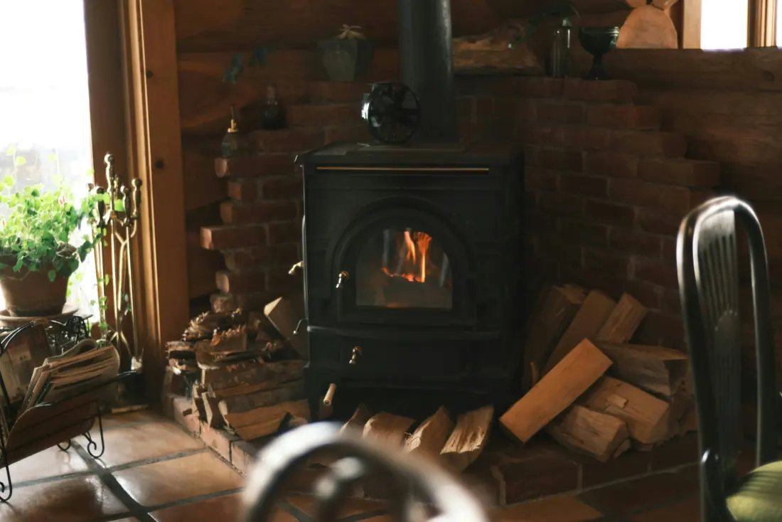 Kaminofen mit brennendem Holz in einer gemütlichen Stube